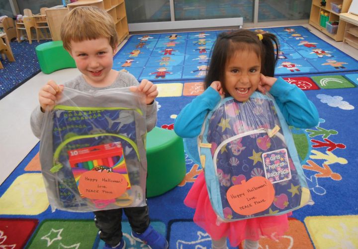 Children holding up backpacks