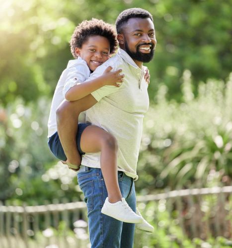 A father carrying his child on his back outdoors