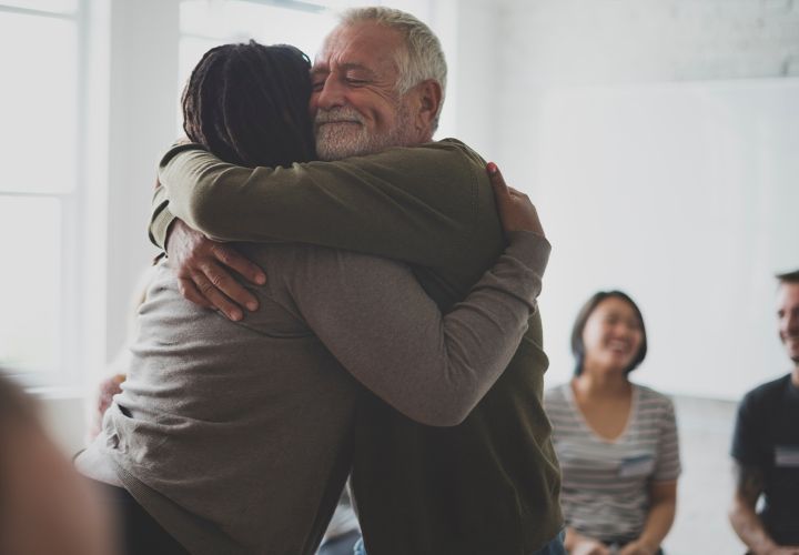 Adults at support group hugging