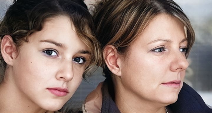 Mother and daughter leaning on eachother