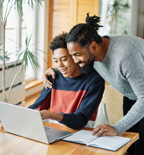 Father helping young son with school work